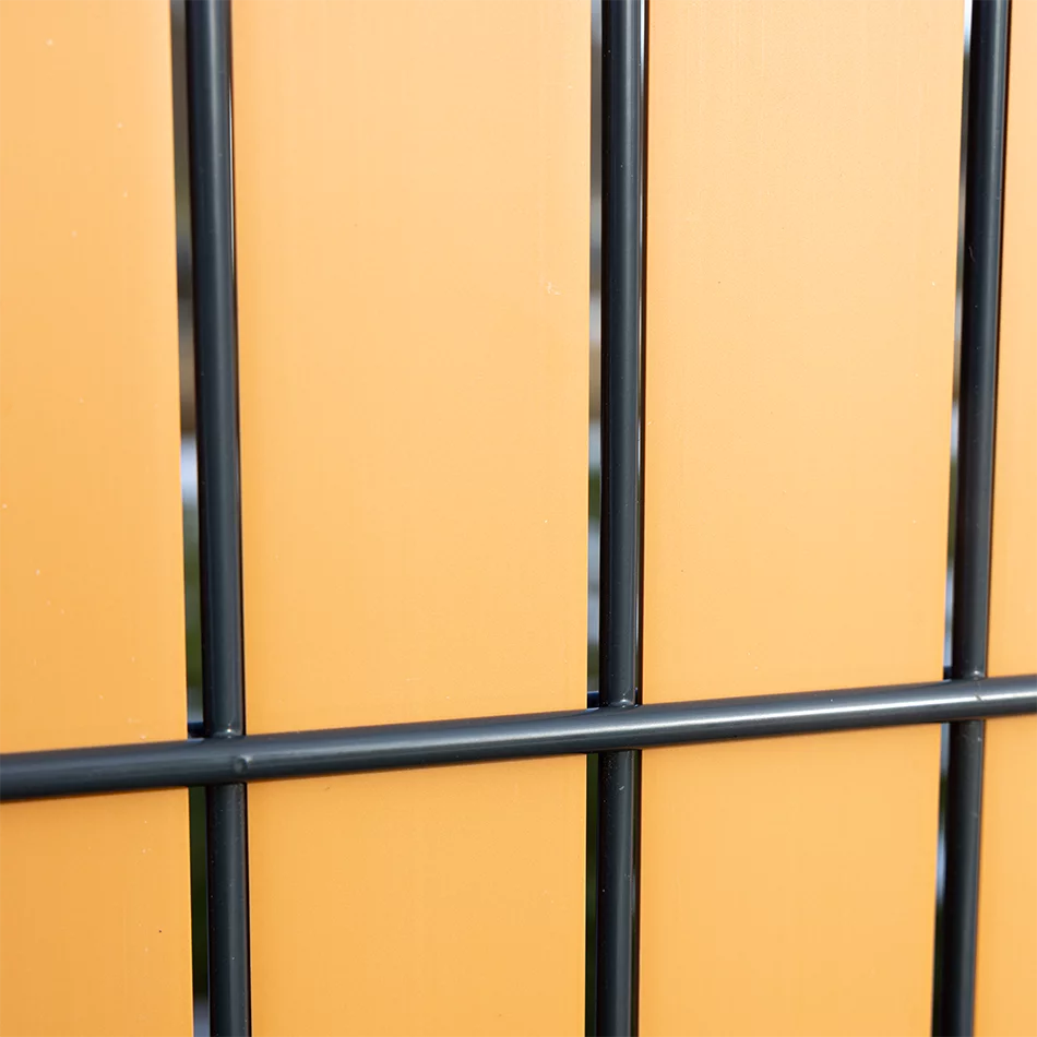 Detailansicht eines anthrazitfarbenen Metallzauns vor bernsteinfarbenem Sichtschutz Flexio Wodewa