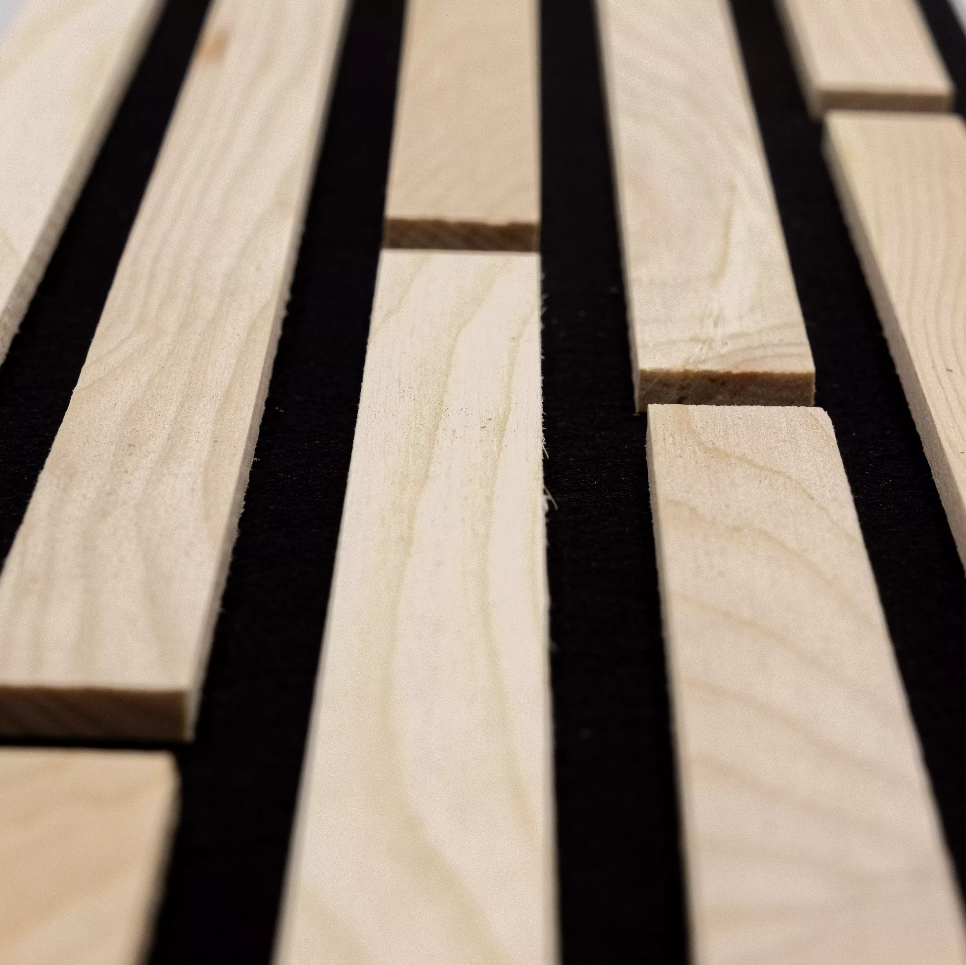 Akustikpaneele aus Zirbe mit schwarzem Filz als moderne Wanddeko zur Verbesserung der Raumakustik in Innenräumen von Wodewa