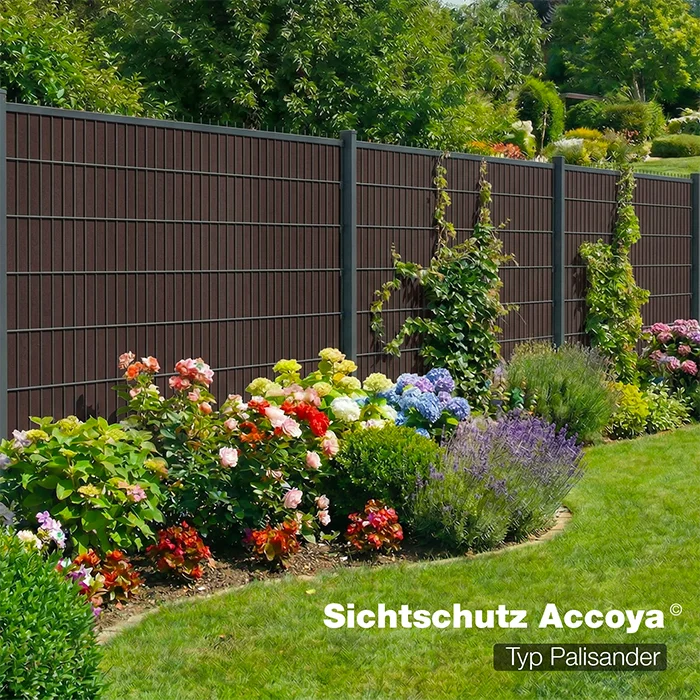 Sichtschutzzaun Accoya Typ Palisander als Gartenzaun mit blühendem Beet im Hintergrund