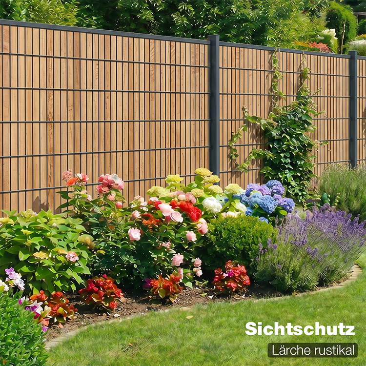 Sichtschutzzaun Lärche rustikalals Gartenzaun mit blühendem Beet im Hintergrund