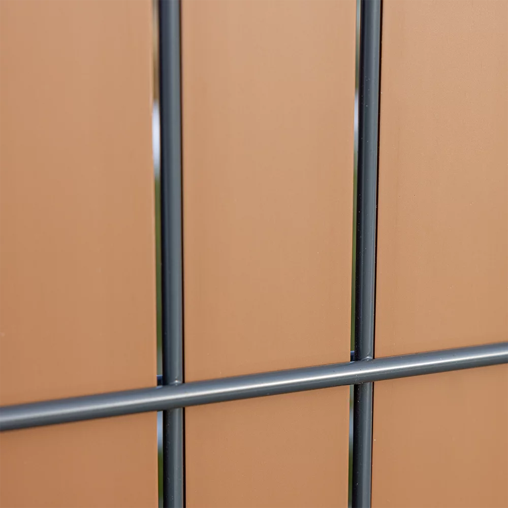 Detailansicht eines anthrazitfarbenen Metallzauns vor copperfarbenem Sichtschutz Flexio Wodewa