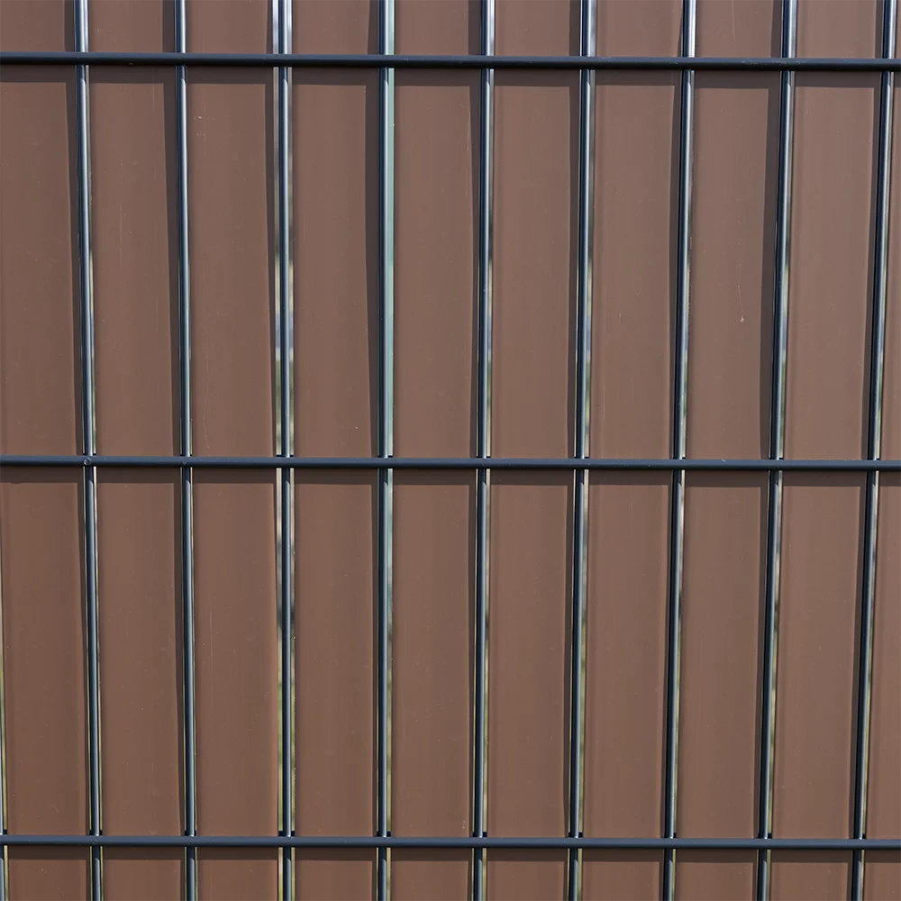 Detailansicht eines anthrazitfarbenen Metallzauns vor copperfarbenem Sichtschutz Flexio Wodewa